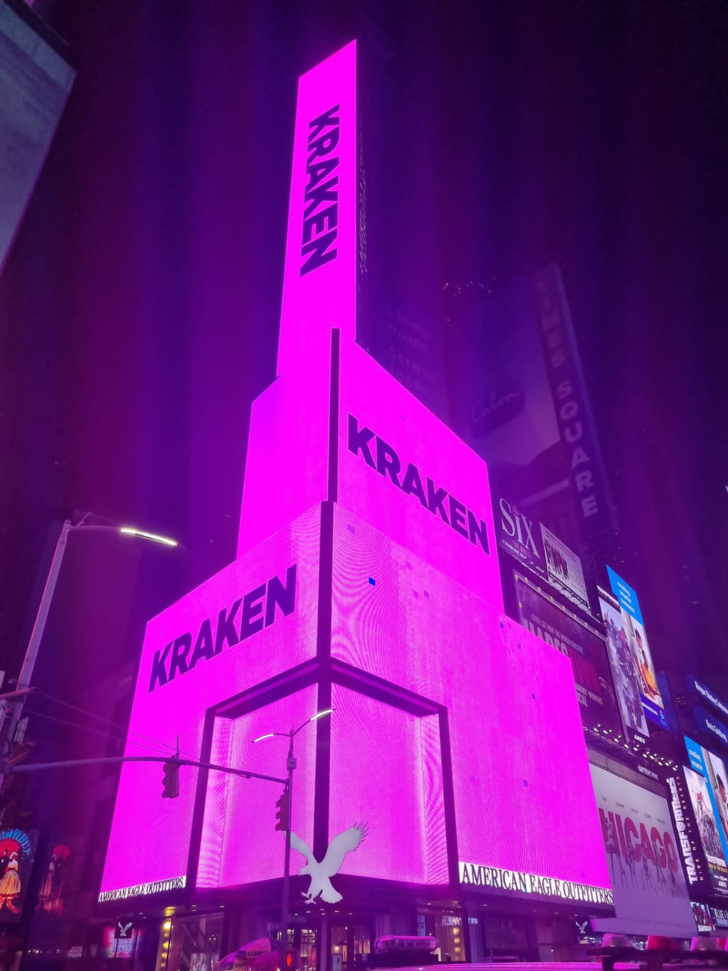 Kraken branding lighting up a Times Square tower screen at night